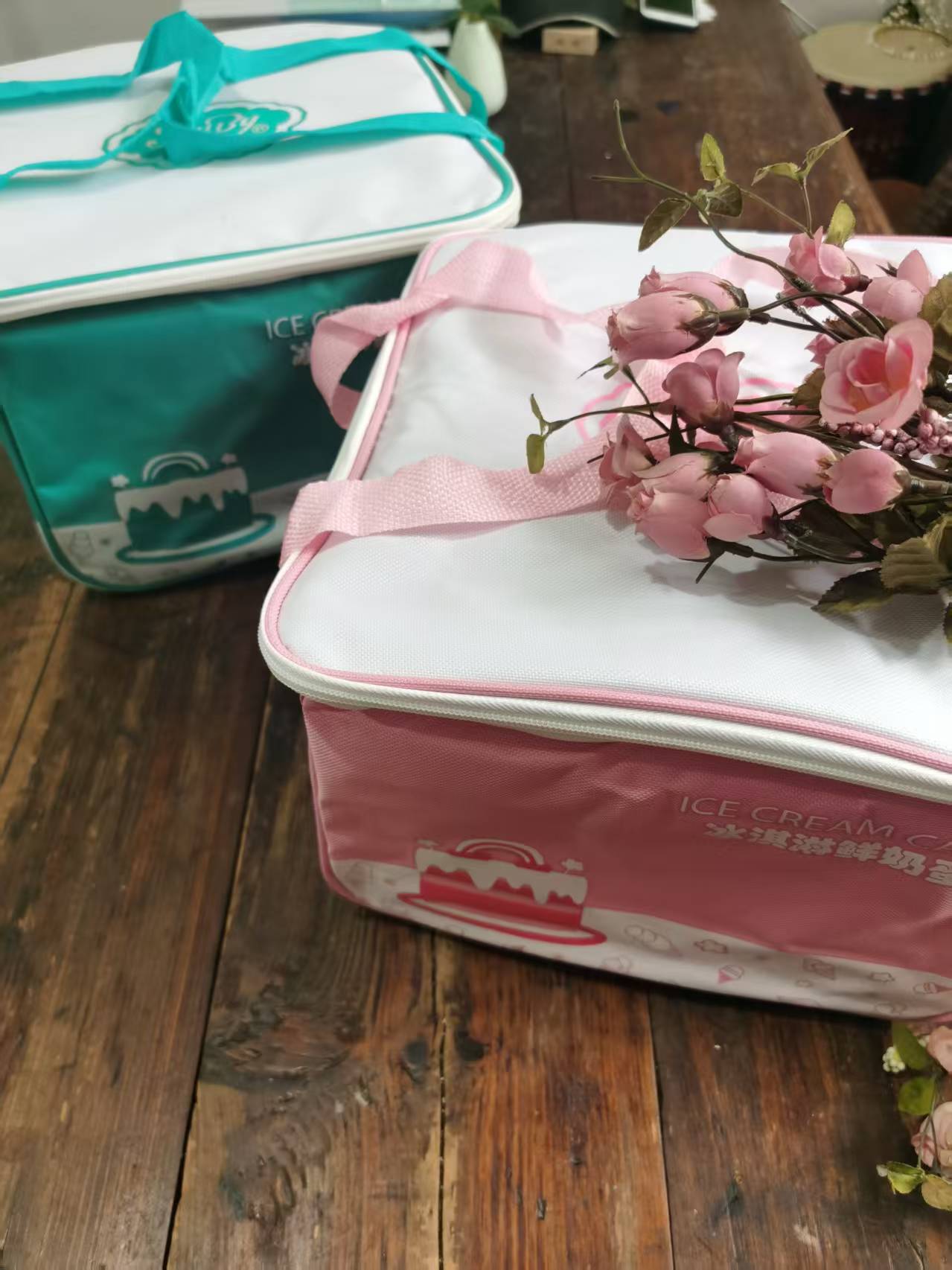 Teal and pink insulated cooler bags side by side