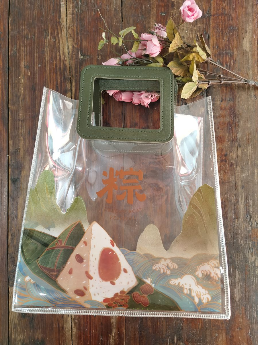 Clear PVC tote bag with green leather handles and festival zongzi print